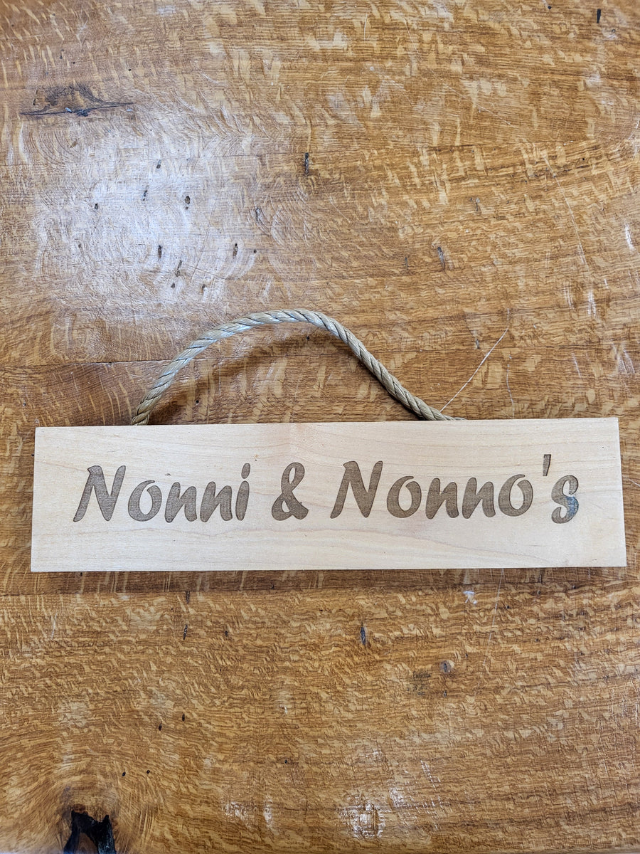 Wooden sign with 'Nonni & Nonno's' engraved on a wooden surface