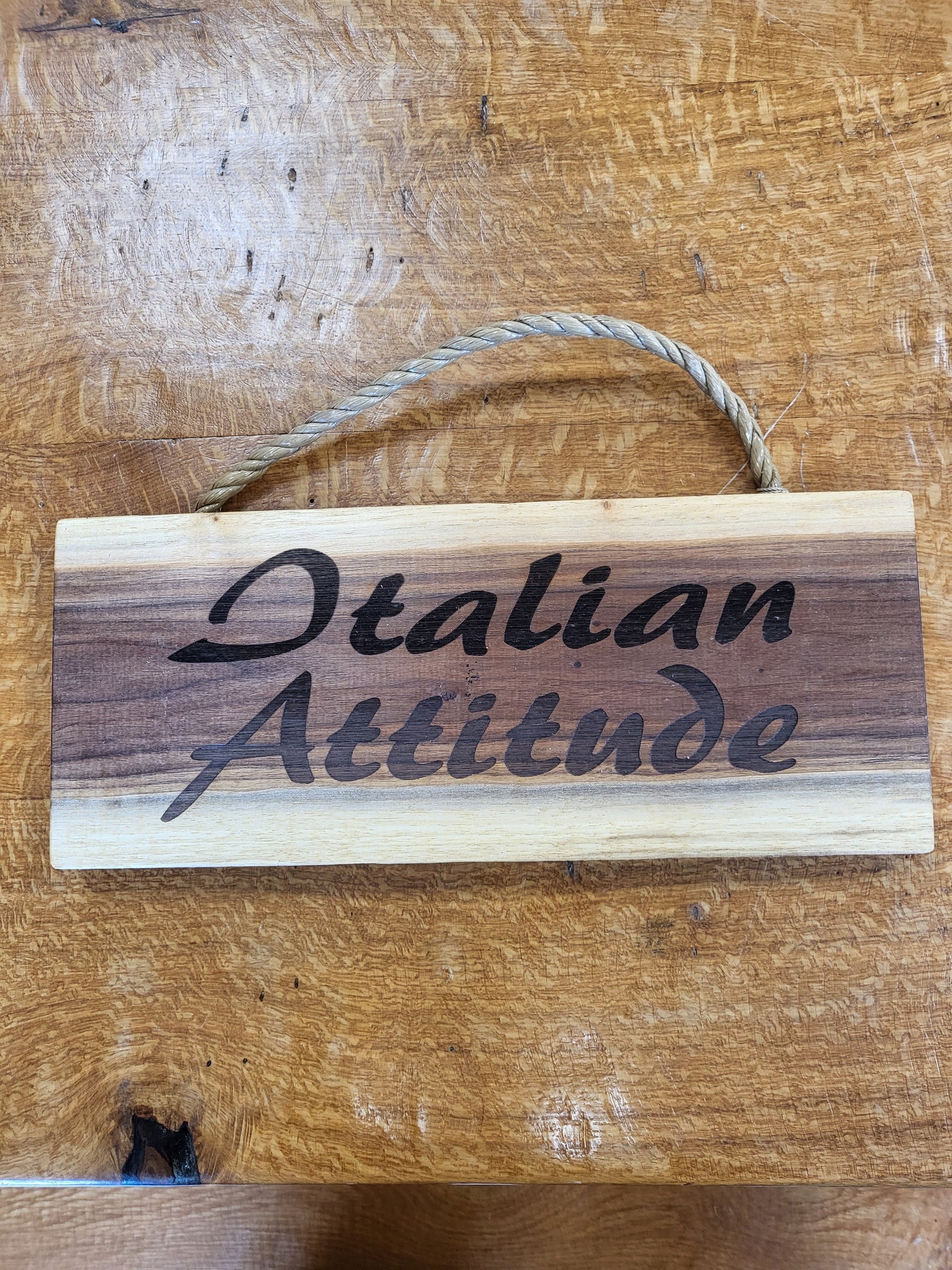 Wooden sign with 'Italian Attitude' text on a wooden surface
