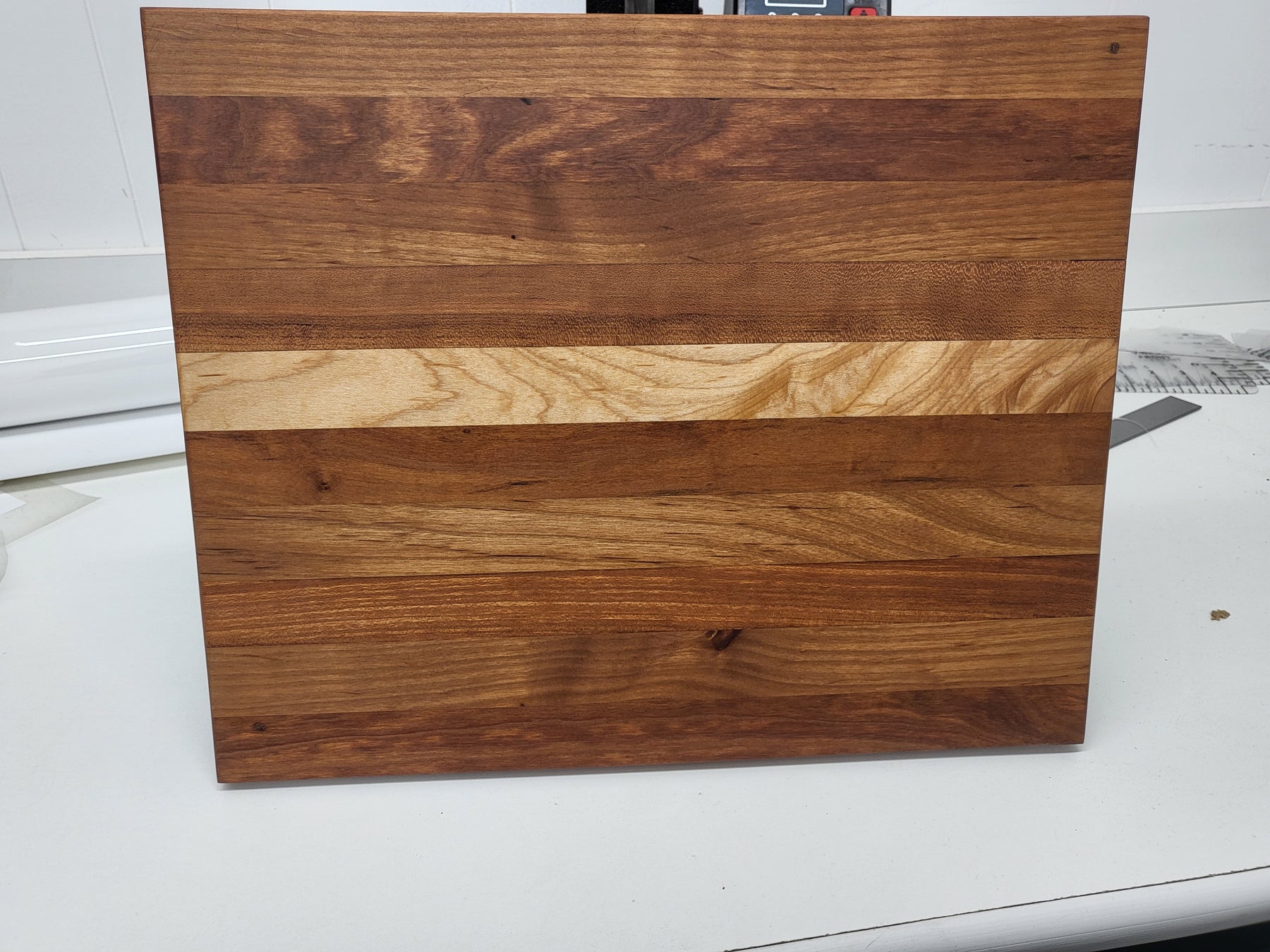 Wooden cutting board with a natural grain pattern on a white surface