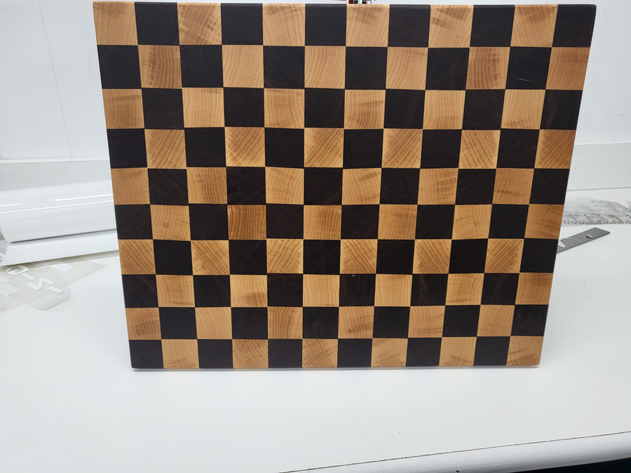 Checkered wooden cutting board on a white surface